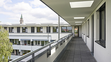 Photo of a close-up of a wooden extension. You can see the access to the individual apartments.