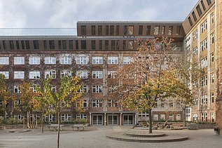 Photo of the wooden extension to the Metropolitan School Berlin. You can see a large multi-storey building.