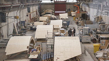 Foto einer Produktionshalle mit mehreren geschwungenen Holzschalen