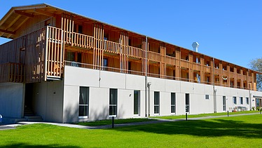 Photo of the yacht club clubhouse in Prien am Chiemsee. You can see a modern wooden building.