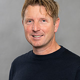 Foto eines lachenden Mannes, mit blonden Haaren. Anders Übelhack.