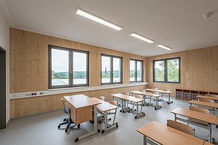 Innenaufnahme der Schule in Erfurt. Man sieht ein Klassenzimmer und eine LENO-ADD-Holz-Außenwand.