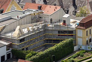 Photo of an aerial view. You can see a wooden extension with LENO cross-laminated timber elements.