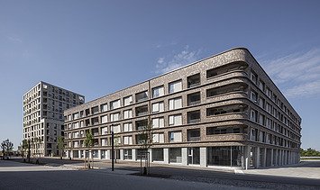 Foto eines großen mehrgeschossigen Gebäudes mit Holzfassade. BUGA-Areal Mannheim.