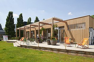 Photo of a wooden building with flat roof and terrace.