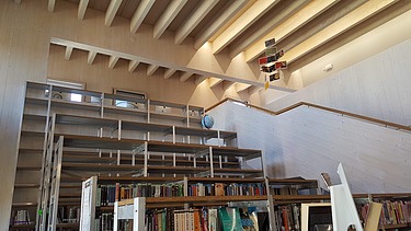 Photo of a library with a visible ribbed wooden ceiling.
