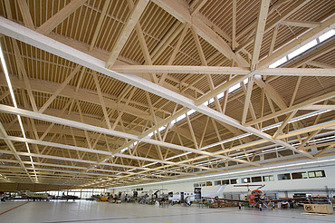 Foto der Montagehalle Pilatus CH-Stans. Zu sehen ist eine große Brettschichtholz-Dachkonstruktion.