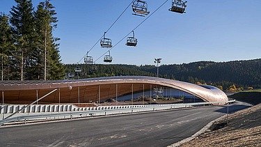 Foto einer Rodelbahn. Man sieht auch einen Sessellift im Bild.