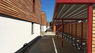 Photo of the student hall of residence in Golm. You can see several wooden buildings and a bicycle shelter.