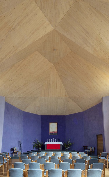 Foto eines Innenraums einer Kapelle mit großer gewölbter Holzdecke