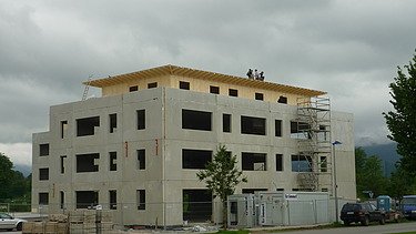 Foto der Montage der Aufstockung des NOVA Centers in Bad Tölz. Zu sehen ist ein mehrgeschossiges Gebäude.