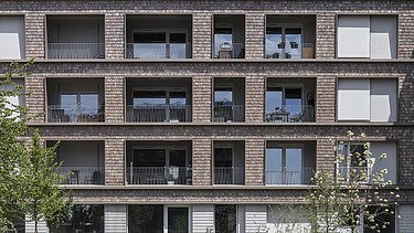 Foto eines großen mehrgeschossigen Gebäudes mit Holzfassade. BUGA-Areal Mannheim.