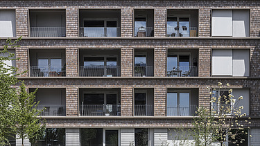 Photo of a large multi-storey building with a wooden façade. BUGA area Mannheim.