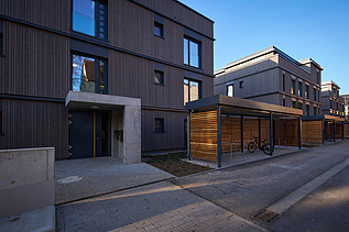 Photo of a multi-storey residential building with a wooden façade.