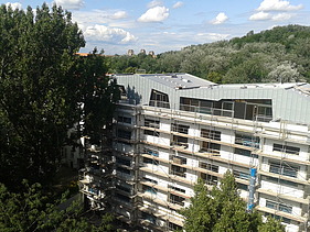 Foto eines mehrgeschossigen Gebäudes. Aufstockung aus Holz.