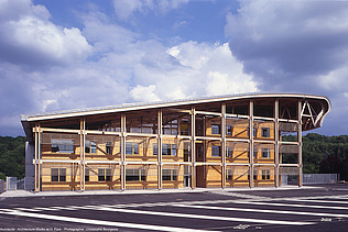 Foto der Schule Mirecourt in Frankreich. Man sieht ein großes Holzgebäude.