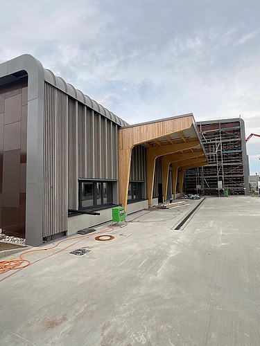 Photo of the Erbe construction site in Rangendingen. You can see large glulam beams at the entrance area.