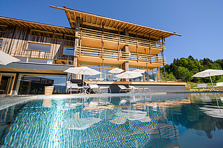 Photo of a wooden hotel with pool.