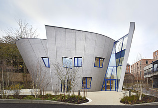 Foto eines Gebäudes mit Holzfassade und schrägen Wänden