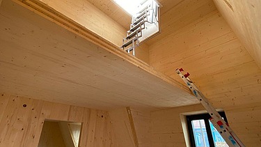 Innenraumfoto einer Aufstockung aus Holz. Man sieht viele zusammengesetzte LENO-Elemente.