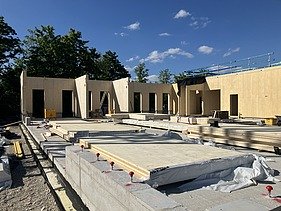 Construction site photo showing the assembly of the first cross-laminated timber elements.
