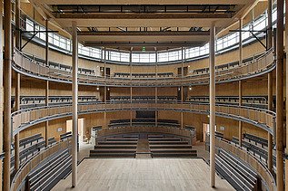 Photo of the Elizabethan Theater in Condette France. You can see a round interior with many wooden surfaces.