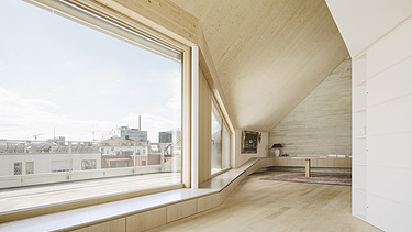 Photo of a modern interior with a large glass front and visible LENO cross-laminated timber elements.