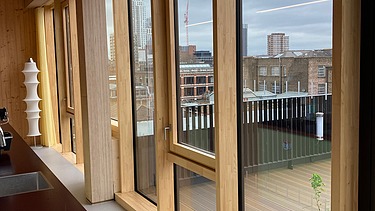 Photo of an interior of the Black and White office in London. You can see a timber mullion and transom façade.