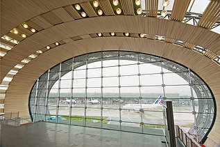 Photo of the Charles de Gaulle Paris airport terminal from the inside. Curved wooden construction.