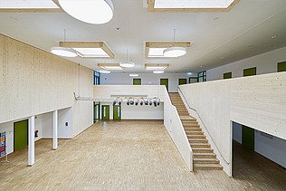 Foto eines Flurbereichs der Schule in München. Man sieht eine Treppe und ein Foye.