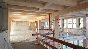 Foto der Montage des UmweltHauses in Nürnberg. Man sieht Holzelemente.