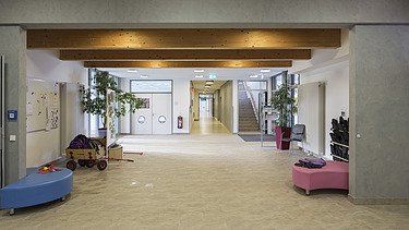 Innenaufnahme der Kindertagesstätte Campeon Infineon in Neubiberg. Man sieht einen möblierten Flurbereich.