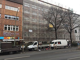 Photo of the wooden extension to the Metropolitan School Berlin. You can see a large multi-storey building.