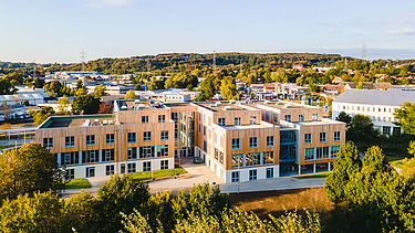 Photo of Witten University from the outside. You can see a large wooden building.
