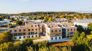 Photo of Witten University from the outside. You can see a large wooden building.
