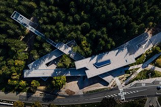 Aerial view of the visitor center in Ruhestein. You can see a building complex in the middle of a forest.
