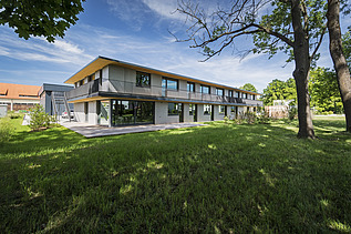 Foto der Anwaltskanzlei FGS Augsburg. Modernes Holzgebäude mit Flachdach.