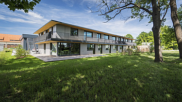 Foto der Anwaltskanzlei FGS Augsburg. Modernes Holzgebäude mit Flachdach.