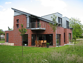 Foto eines Holzhauses mit Klinkerfassade. LENO-BSP.