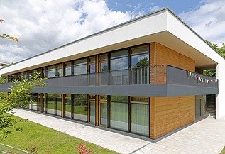 Kita Frankfurt Außenaufnahme der Kita in Frankfurt. Man sieht ein Gebäude aus Holz mit Flachdach.