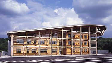 Photo of the Mirecourt school in France. You can see a large wooden building.