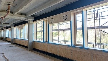 Foto eines Innenraumes auf der Baustelle. Man sieht eine eingebaute Holzrahmenbauwand.