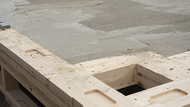 Photo of a horizontal rib element with a layer of concrete in the ZÜBLIN Timber production hall.