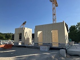 Construction site photo showing the assembly of the first cross-laminated timber elements.