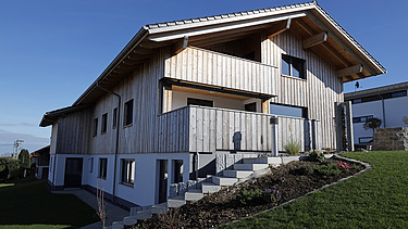 Foto eines Wohnhauses aus LENO-Brettsperrholz mit Holz-Putzfassade.