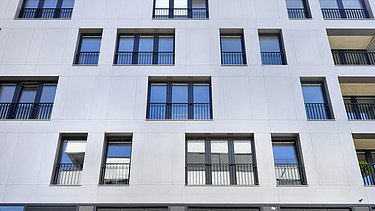 Foto des Gebäudes SKAIO Stadtsiedlung in Heilbronn. Man sieht ein mehrgeschossiges, weißes Gebäude und einen Fassadenausschnitt davon.
