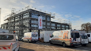 Exterior shot of the ZÜBLIN Neu-Ulm office shell. You can see a scaffolded wooden building.