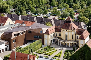 Aerial view of several buildings, including a church and extension made of LENO cross-laminated timber.