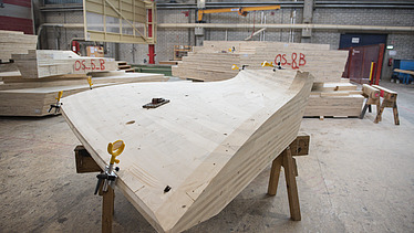 Photo of a curved LENO element in the ZÜBLIN Timber production hall.