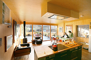 Foto eines Küchenwohnraumes mit vielen Holzoberflächen.